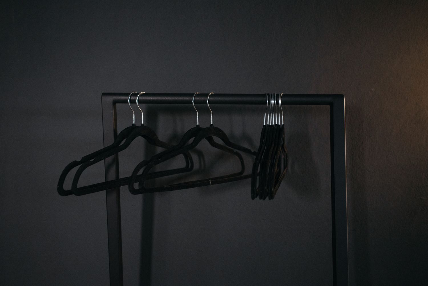 Black clothes hangers on a rail