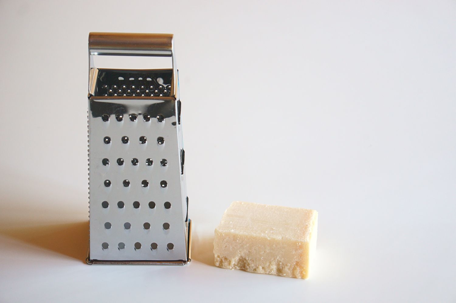 Cheese beside a box grater