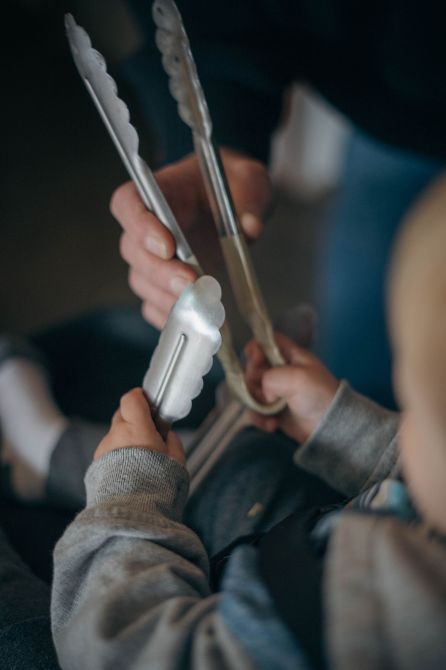 Hands holding kitchen tongs