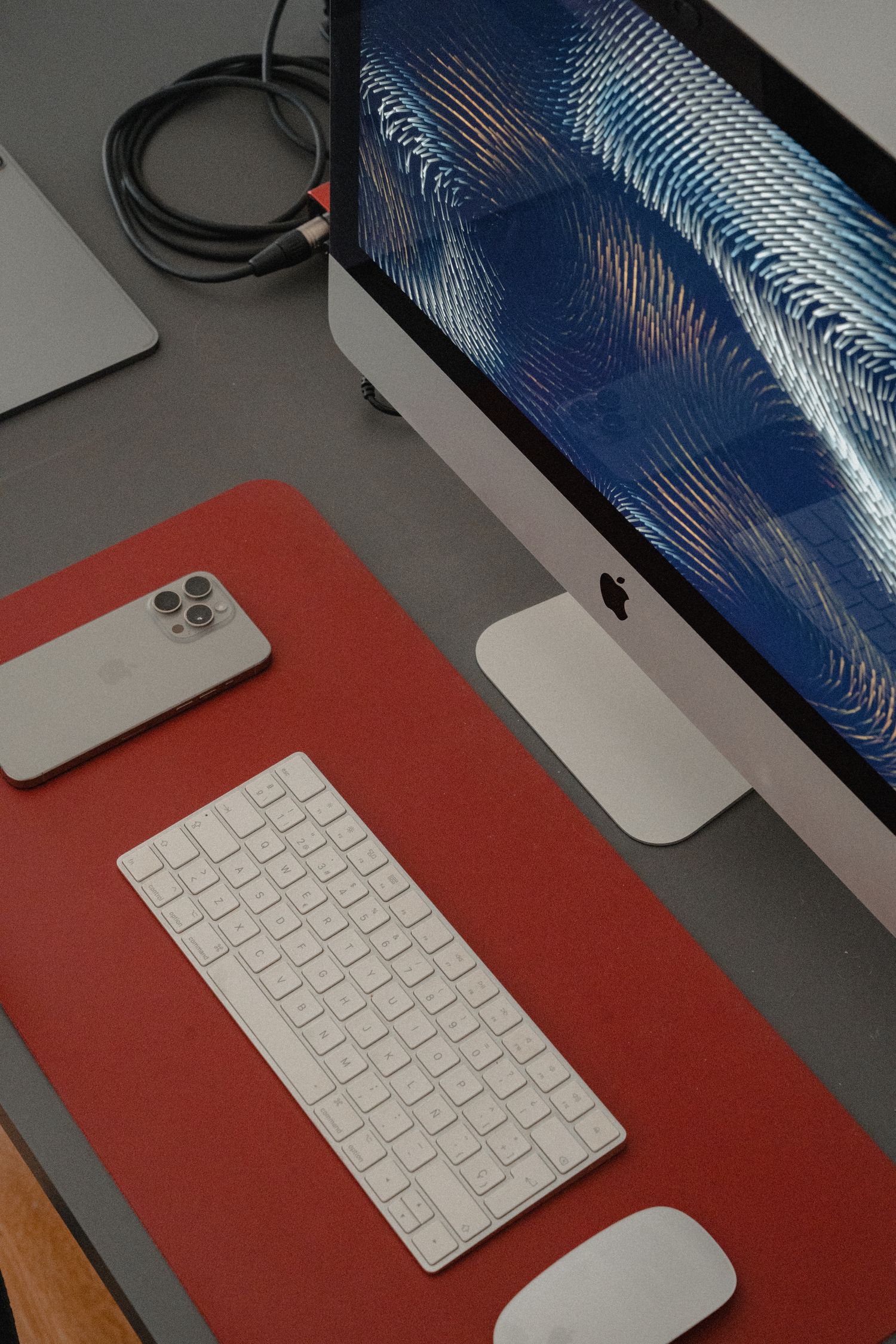 Keyboard and mouse on a red desk mat