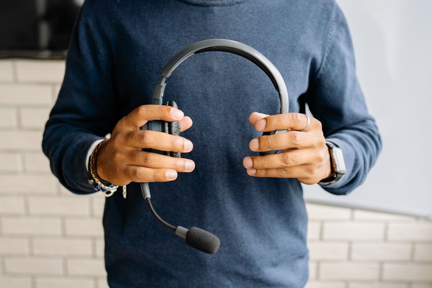 Person holding a headset with a boom microphone