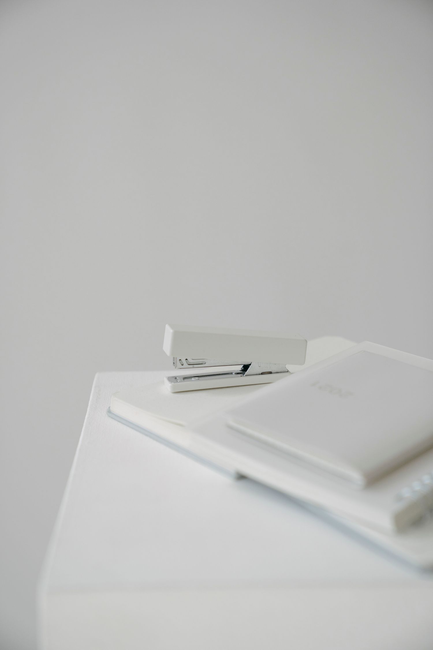 White stapler beside paper on a desk