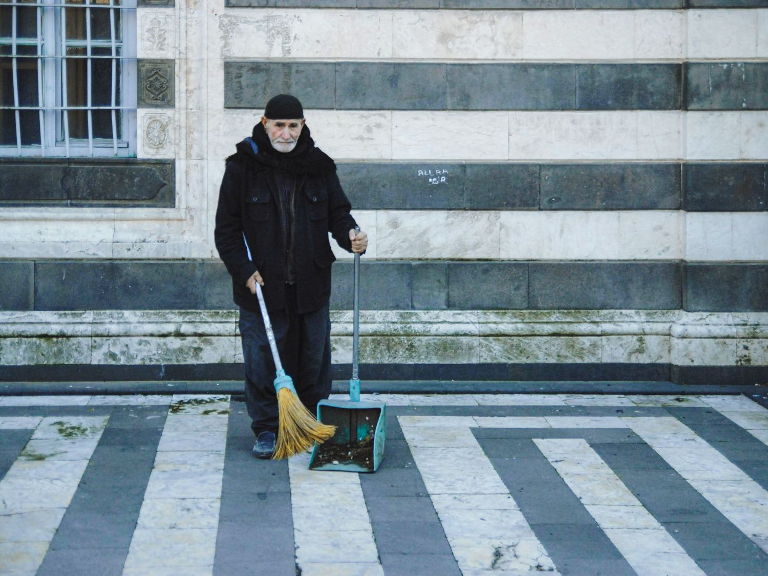 Person sweeping debris into a dustpan
